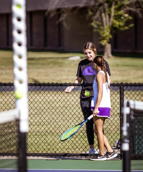 Soli Groff instructs Alexa Salas during tennis match.